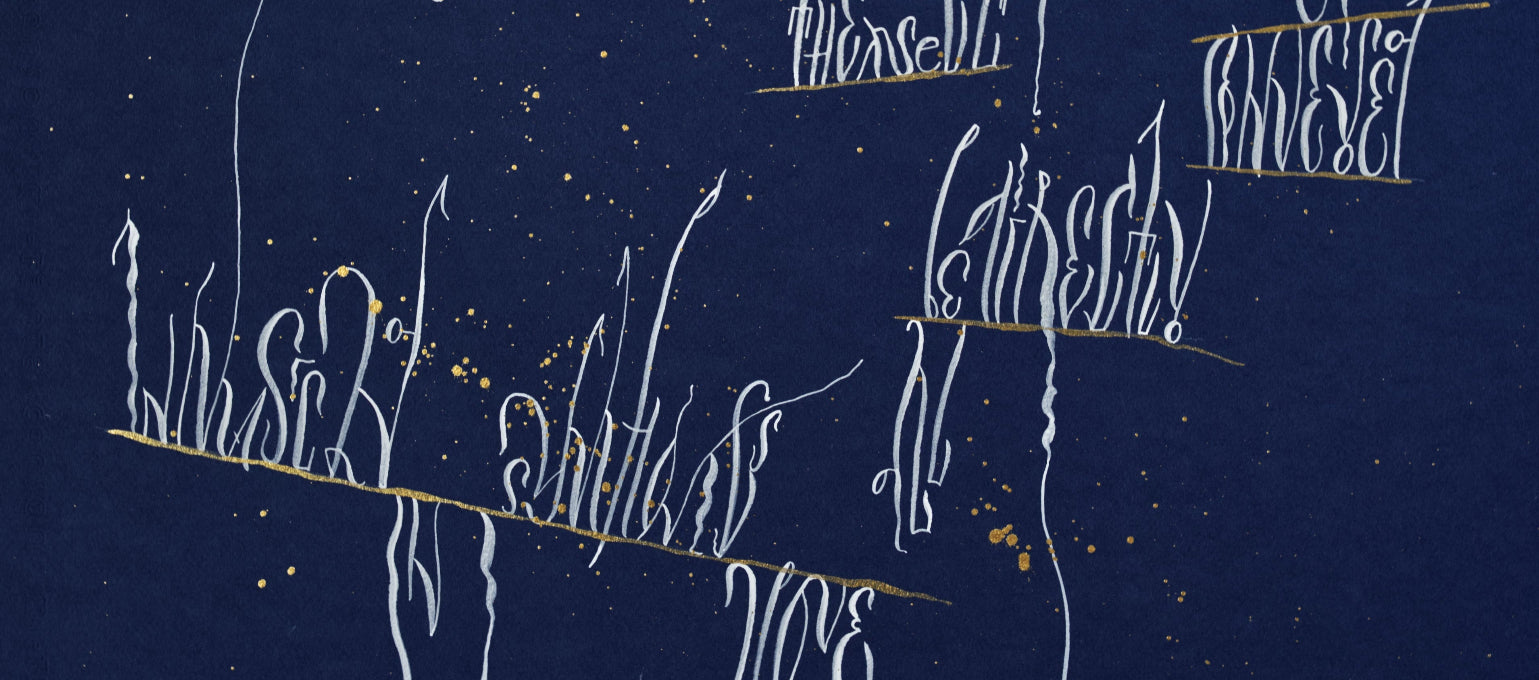 white calligraphy on dark blue paper with gold splashes