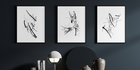 Three prints from the collection are hanging on the dark wall