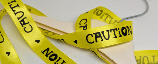 Yellow ribbon with bola black text lettering "Caution"