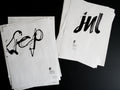 Twenty sheets of paper with black calligraphy on a dark background