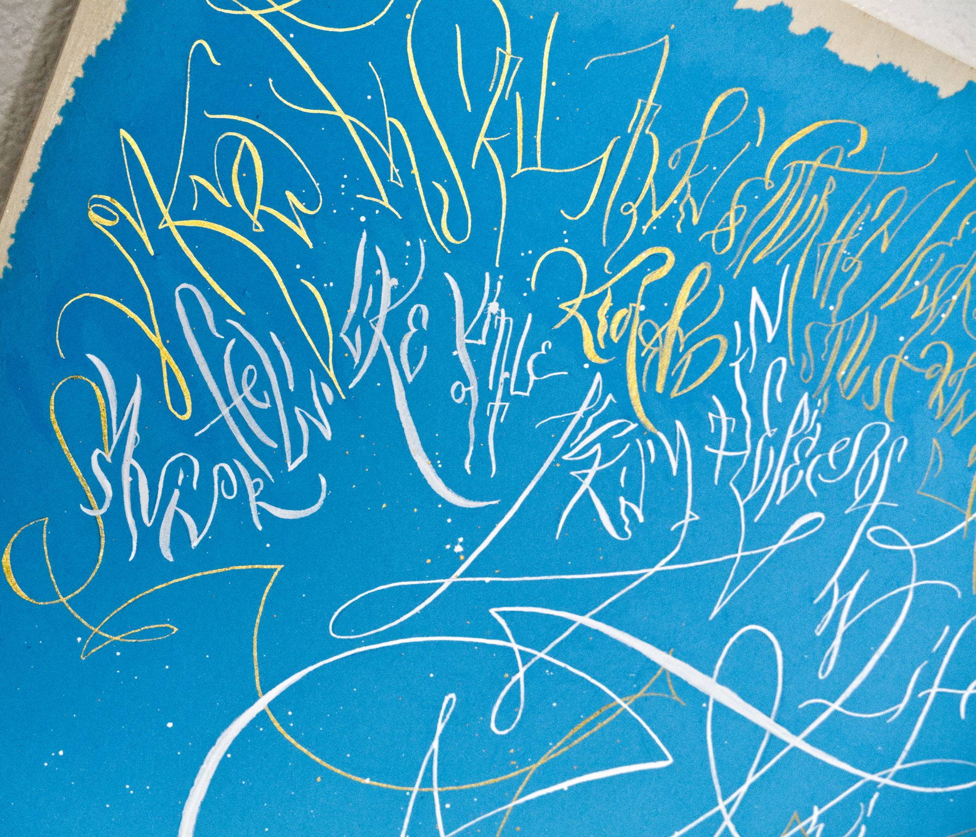Close up of the artwork Standing still on blue paper with white and gold calligraphy