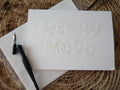 White greeting card with 'Merry mood' embossed text and gold decorations