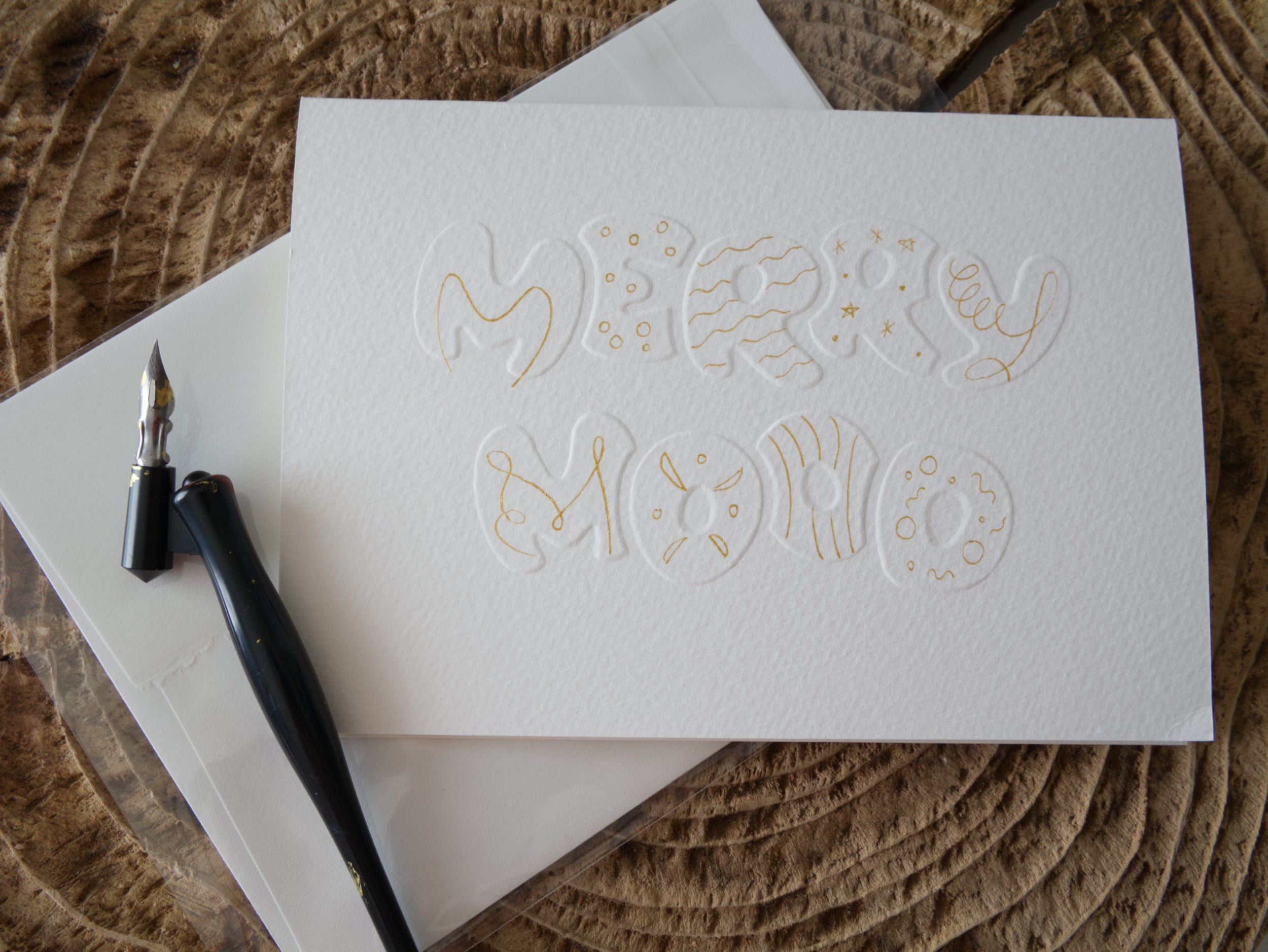 White greeting card with 'Merry mood' embossed text and gold decorations
